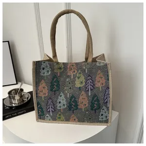 Close-up of linen tote bag featuring a Christmas tree pattern and durable rope handles