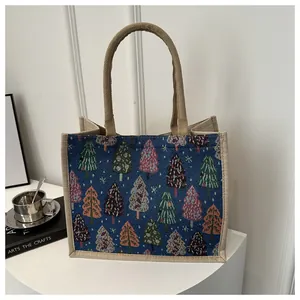 Detail of Christmas tree print linen tote bag with sturdy handles and woven texture