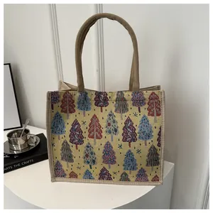 Close-up of the woven texture and colorful Christmas tree patterns on the linen tote bag