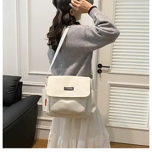 Detailed back view of a person wearing a beige canvas messenger bag with a stylish patch
