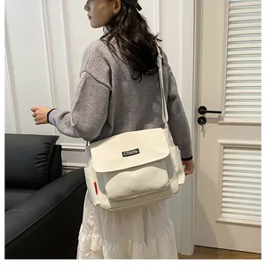 Detailed side view of white canvas messenger bag with adjustable strap and 'СТИЛЬ' label