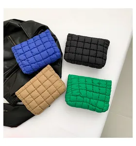 Detailed view of puff quilted cosmetic bags in blue, black, khaki, and green colors