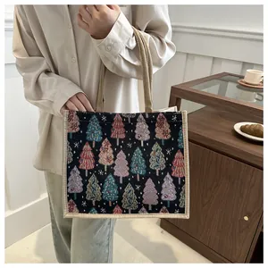 Close-up of linen tote bag with colorful woven Christmas tree patterns and sturdy handles