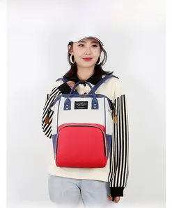 Close-up of tricolor diaper backpack with Living Traveling Share label and metal zippers