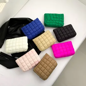 Gesteppte Puffer-Kosmetiktaschen in vielen Farben auf einer schwarzen Jacke präsentiert