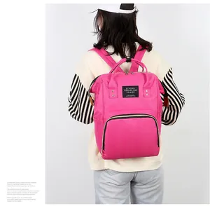 Rear view of model wearing a bright pink large capacity nylon mommy backpack