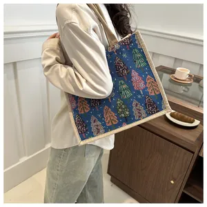 Navy linen tote bag with colorful Christmas tree patterns and beige woven handles
