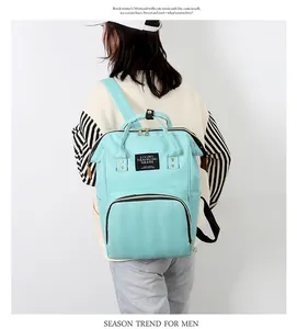 Detail view of mint green backpack with adjustable straps and front zip pocket