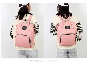 Pink multi-functional diaper backpack featuring durable top handles and large front pockets