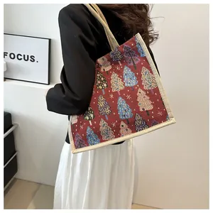 Detailed close-up of a red linen tote bag with colorful Christmas tree embroidery pattern