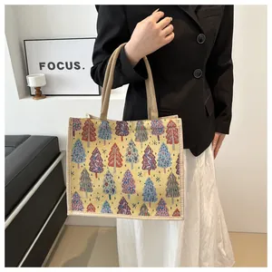 Detail of linen tote bag with colorful Christmas tree jacquard and khaki handles