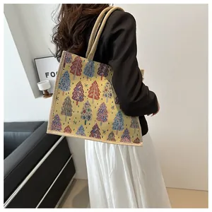 Lifestyle shot of a linen tote bag with colorful Christmas tree patterns on a model