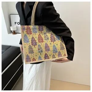 Close-up of woven linen tote bag with colorful Christmas tree patterns and rope handle