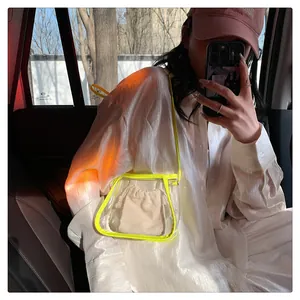 Dettaglio borsa a tracolla in PVC trasparente con bordo giallo neon e sacchetto interno