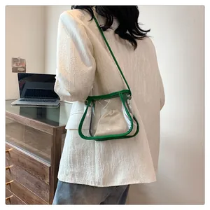Dettaglio borsa a tracolla in PVC trasparente con bordo verde e sacchetto beige