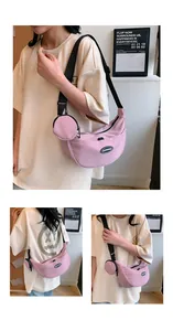 Detailed view of pink nylon crescent crossbody bag with matching round coin purse