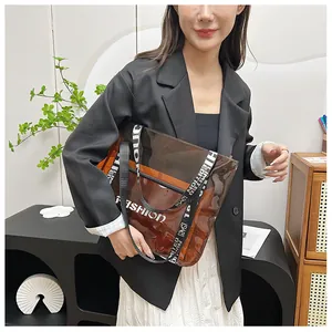 Detail of transparent brown PVC tote bag with Fashion lettering and woven shoulder straps