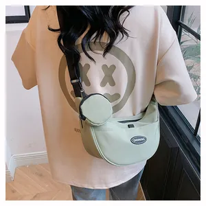 Light green nylon crescent crossbody bag with small round pouch and adjustable strap