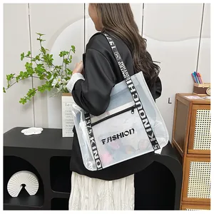 Detail of transparent tote bag featuring black woven strap with white letter printing