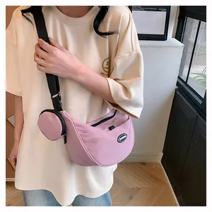Close-up of pink crescent nylon crossbody bag with matching round coin purse detail