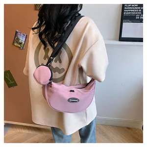 Pink nylon crescent crossbody bag with adjustable strap and matching round coin pouch