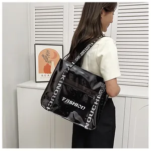 Detail of clear black PVC tote bag featuring fashion letters and woven shoulder strap