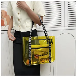 Detail of yellow transparent PVC tote bag with stylish black and white lettered strap