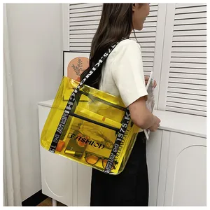Detailed shot of yellow transparent PVC tote with black logo strap and fashion inner pouch