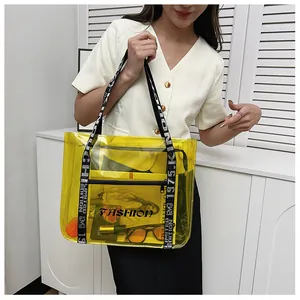 Detail view of yellow transparent PVC tote bag with letter strap and black inner pouch