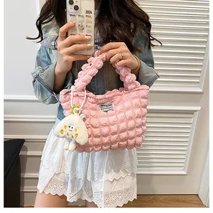 Detalle del bolso rosa con textura de burbujas y un tierno colgante de nube