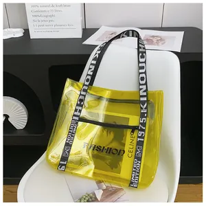 Detail of yellow transparent PVC tote bag with black and white lettered woven shoulder strap