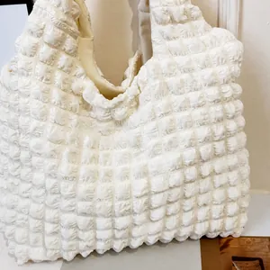 Gros plan du sac à bandoulière blanc nuage avec texture matelassée 3D très douce