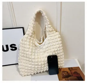 Détail du sac à bandoulière blanc à texture gaufrée avec smartphone pour comparer la taille