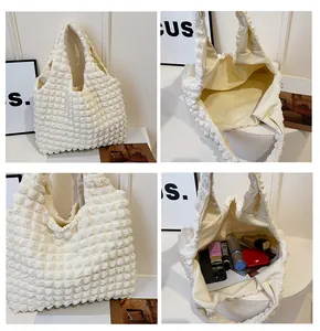 Vue détaillée du sac cabas en tissu bouffant crème montrant l'espace et la texture