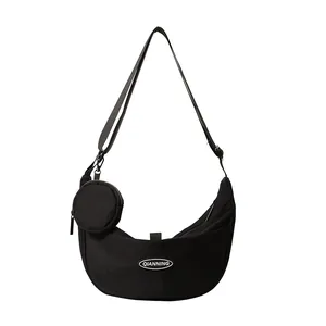 Large black nylon crescent crossbody bag with adjustable strap and small round coin pouch
