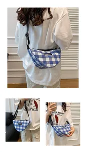Detail of blue and white checkered crescent crossbody bag with adjustable black strap