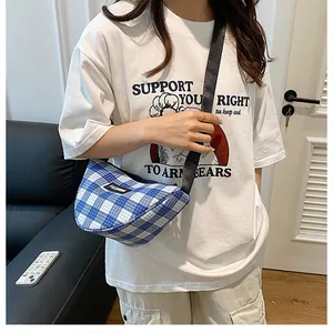 Detailed view of the blue and white checkered half-moon crossbody bag with wide strap