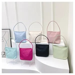 Close-up of lightweight nylon shoulder bags in multiple colors with embroidered lettering