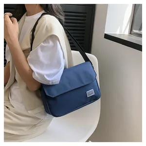 Detailansicht der dunkelblauen Kuriertasche aus Nylon mit Webetikett und verstellbarem Gurt