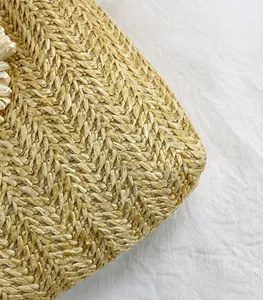 Detailopname van stro vlechtwerk textuur met decoratieve witte bloem voor de tas