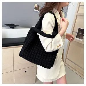 Détail d'un sac cabas noir à texture bouffante montrant le tissu plissé et la grande capacité