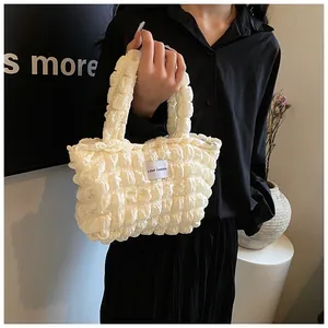 Detail of white bubble texture handbag with LOVE FASHION label on a mini canvas tote bag
