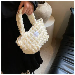 Detail of cream bubble textured shoulder bag with LOVE FASHION woven label detail