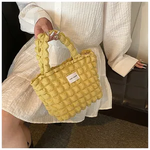Close-up of vibrant yellow bubble texture handbag featuring Love Fashion tag detail