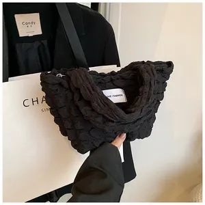 Close-up of black pleated bubble fabric texture and LOVE FASHION woven label on bag
