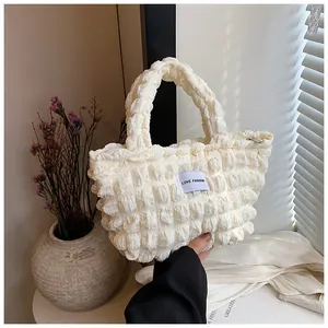 Detail of off-white bubble texture bag with LOVE FASHION label and metal zipper