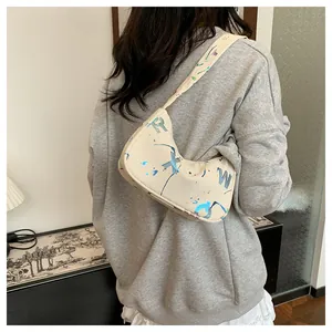 Detail of off-white leather crescent bag with colorful letter graffiti on the side