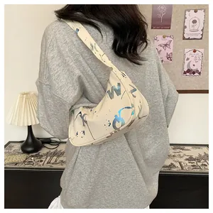 Detailed view of beige underarm bag with colorful graffiti and shoulder strap