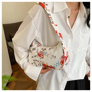 Detailed view of white graffiti hobo bag featuring artistic text prints and street style