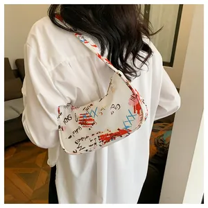 Detail of white underarm bag featuring vibrant street style graffiti and zipper closure